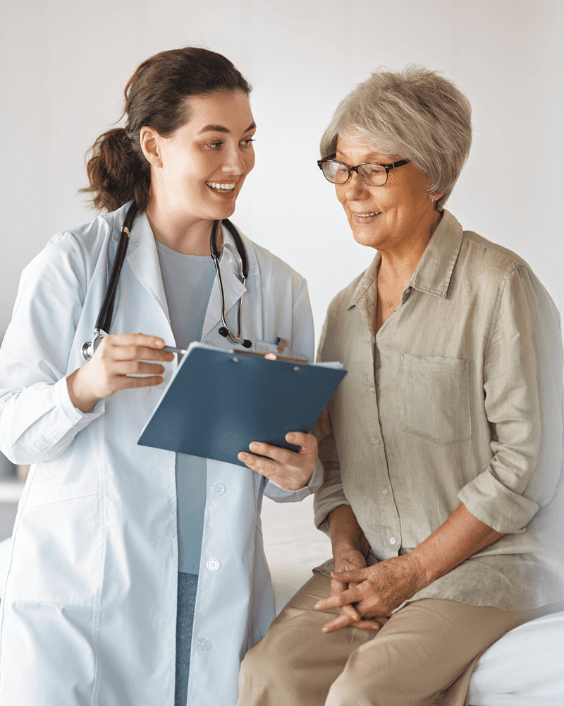 Female doctor consulting senior woman with clipboard