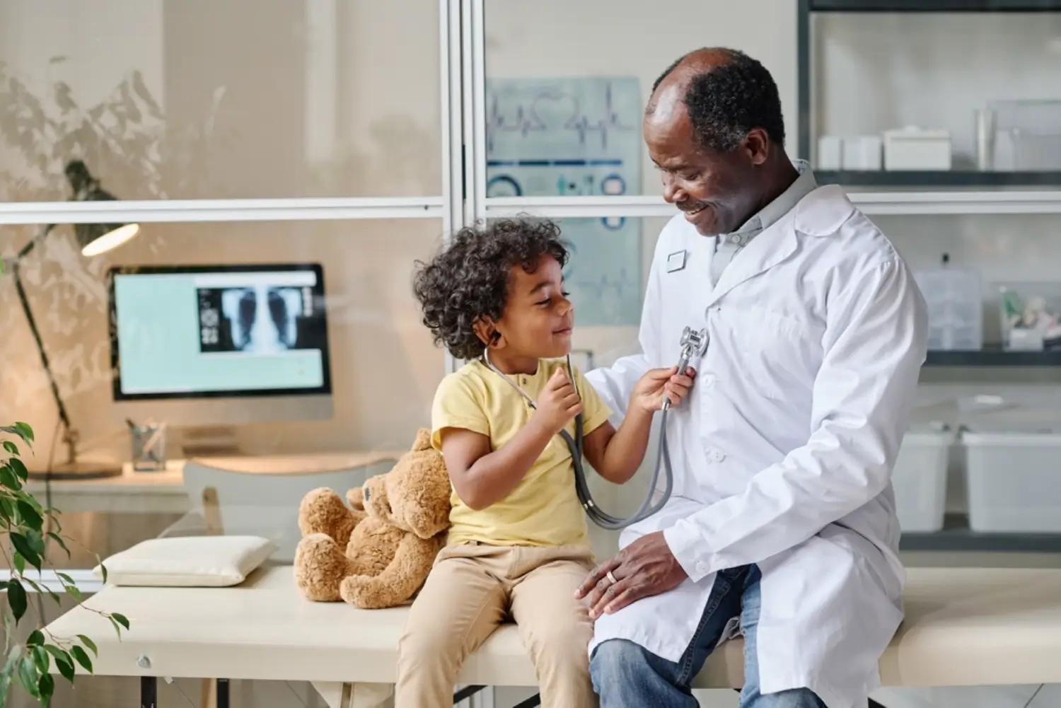 Child uses stethoscope on smiling doctor